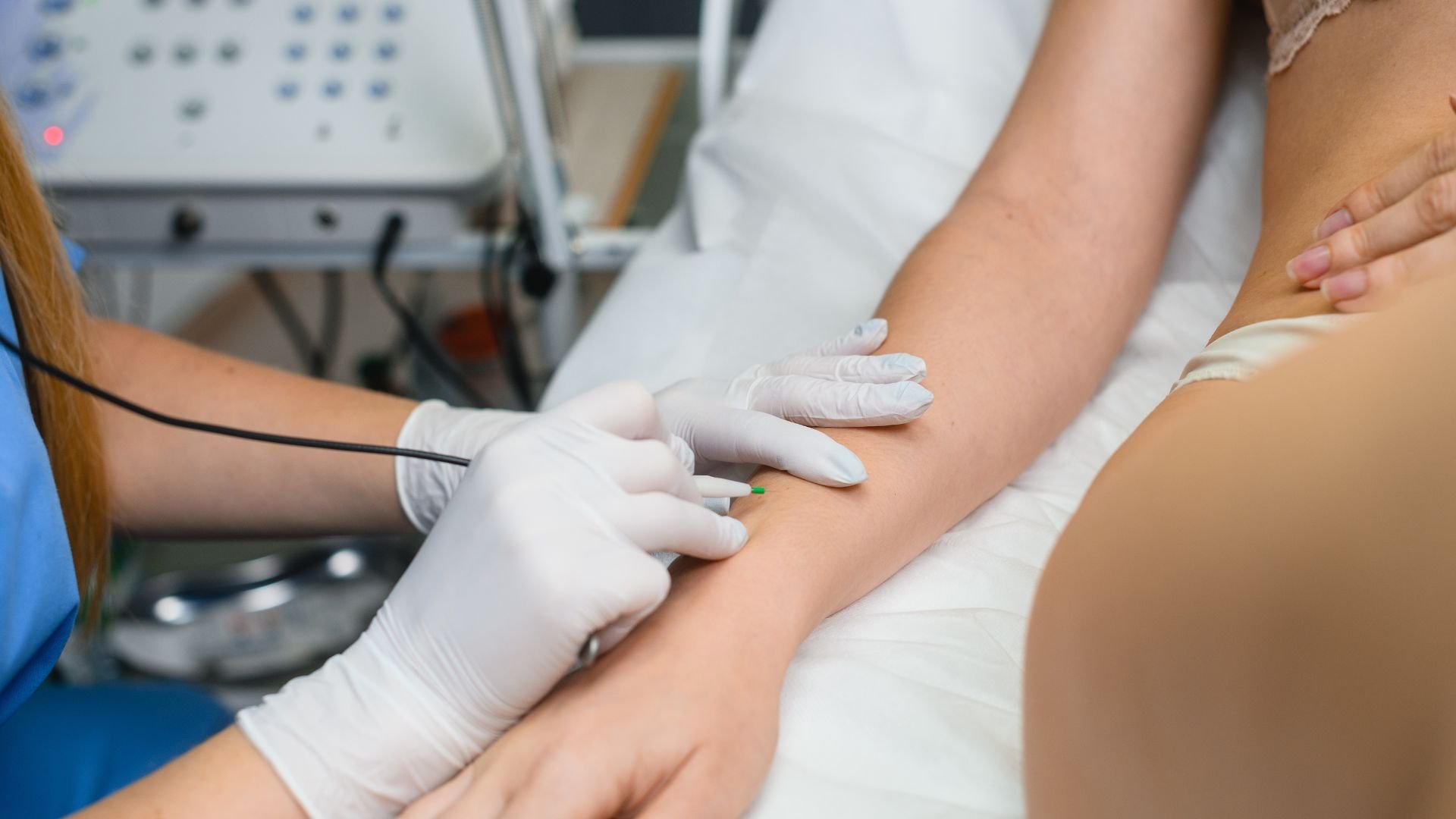 Medical professional performing laser treatment on patient's arm